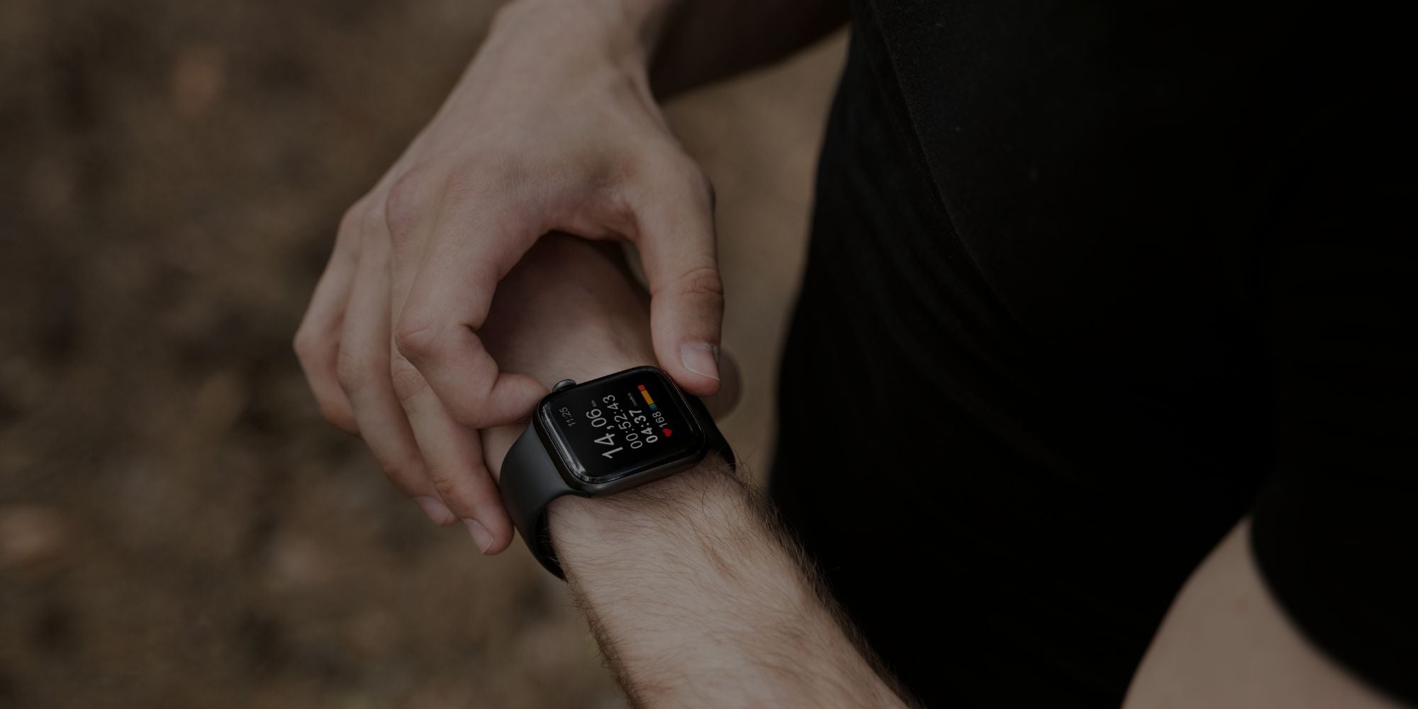 Man checking black smart watch fitness data during outdoor workout session